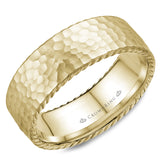 A wedding band in yellow gold with a hammered finish and rope detailing.