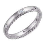 A wedding band in white gold with rope detaining on the sides and 6 round diamonds.