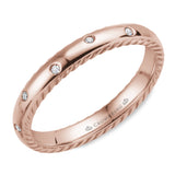 A wedding band in rose gold featuring 12 round diamonds and rope detailing on the sides.