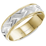 A yellow gold wedding band with a carved and textured white gold center and milgrain detailing.