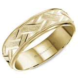 A yellow gold wedding band with a carved and textured center and milgrain detailing.