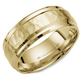 A yellow gold wedding band with a hammered center and beveled edges. 