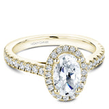 A Noam Carver yellow gold engagement ring with an oval cut center diamond, a halo and 54 diamonds.