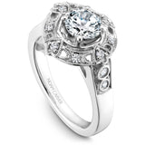 A Noam Carver white gold engagement ring with a round center stone on a detailed halo and 12 diamonds.