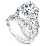 A Noam Carver white gold engagement ring with a cushion halo, 18 round diamonds and a detailed floral band. 