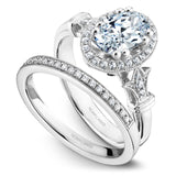 A Noam Carver white gold engagement ring with rose gold floral accents on a setting, an oval cut center stone & 30 diamonds.
